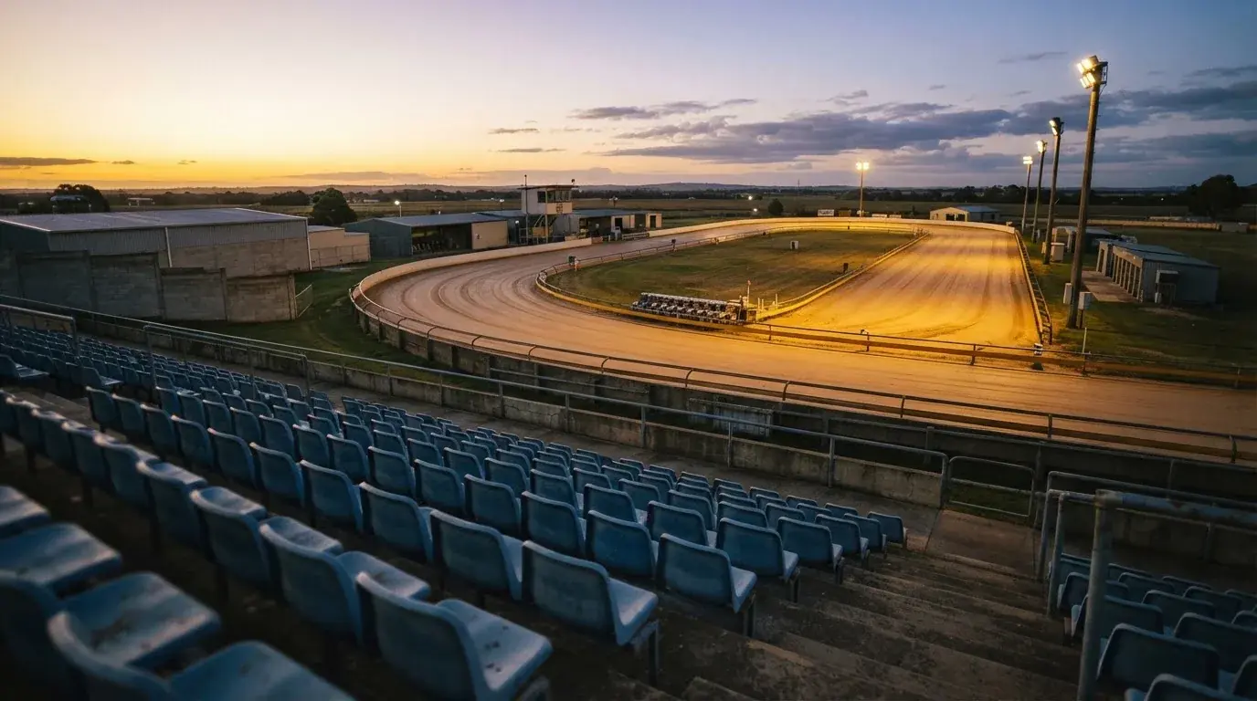 Un estadio de fútbol vacío con torres de iluminación al atardecer